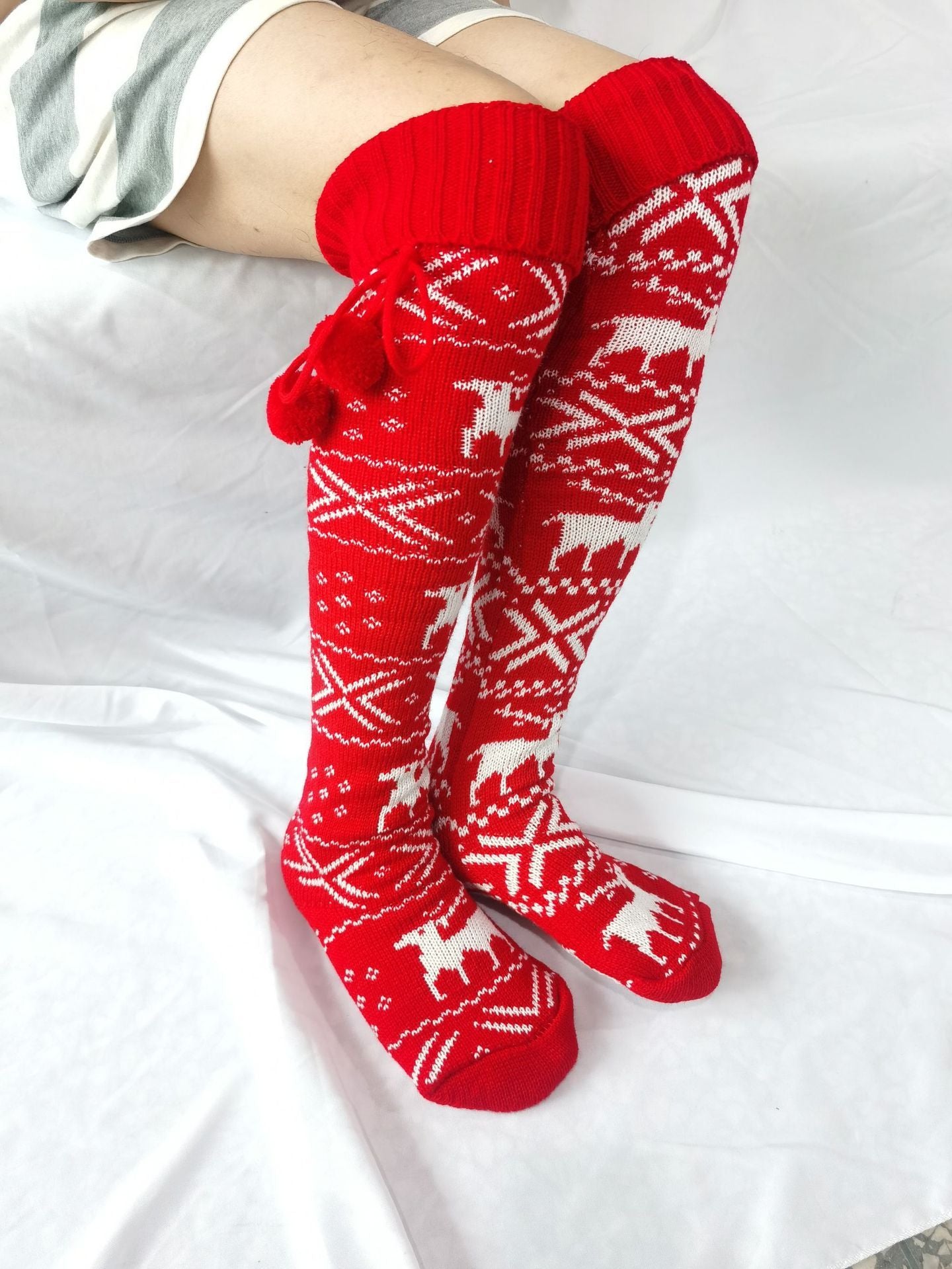 Red knitted socks with white patterns on a white background
