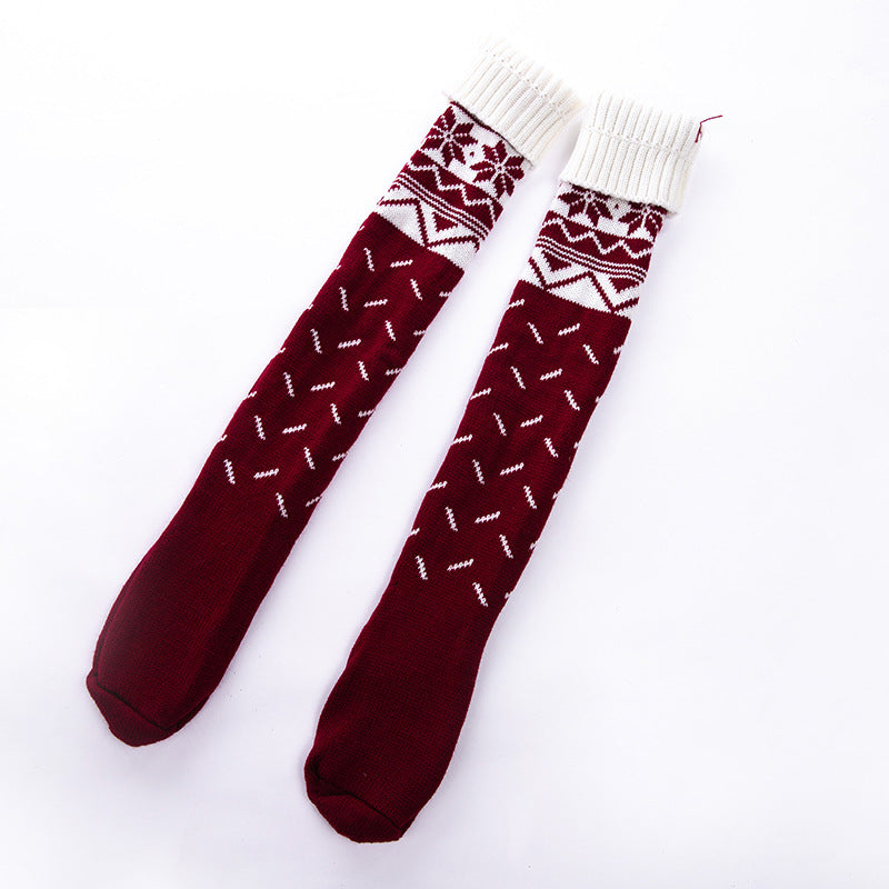 Pair of maroon socks with white patterns on a white background