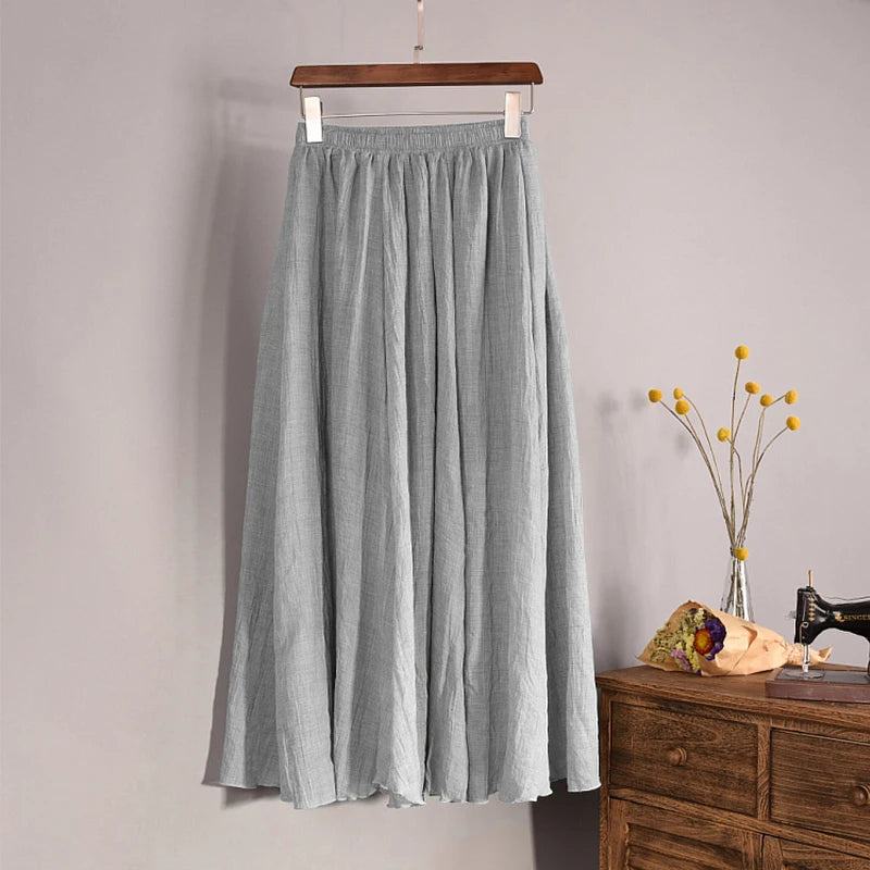 Gray skirt hanging on a wooden hanger against a plain background