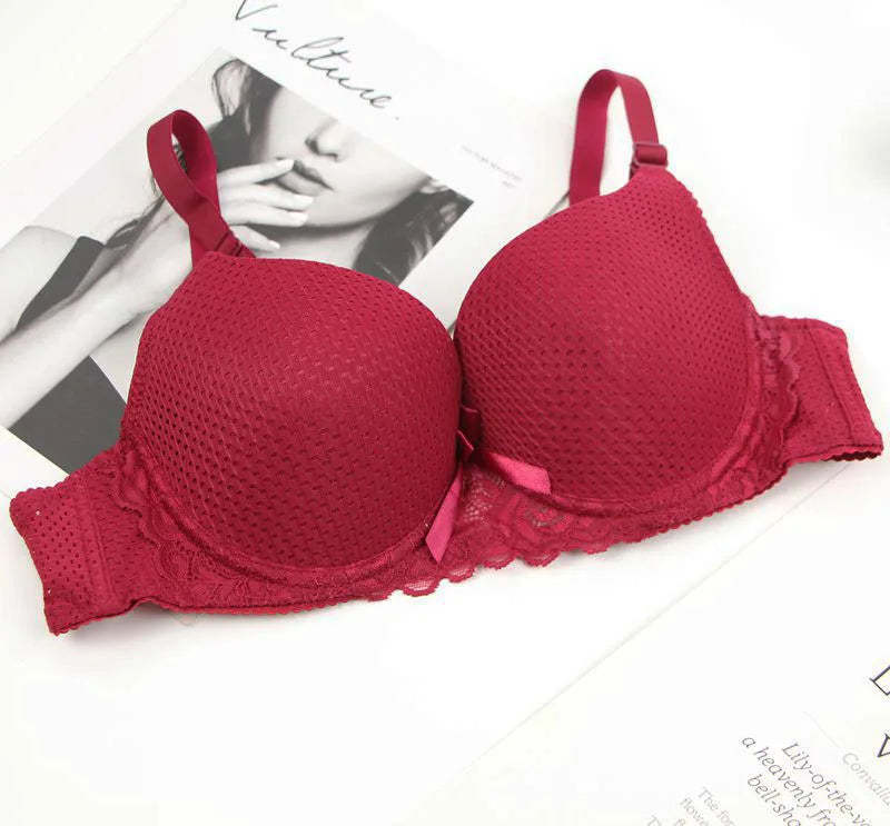 Red bra on a white surface with a blurred magazine in the background