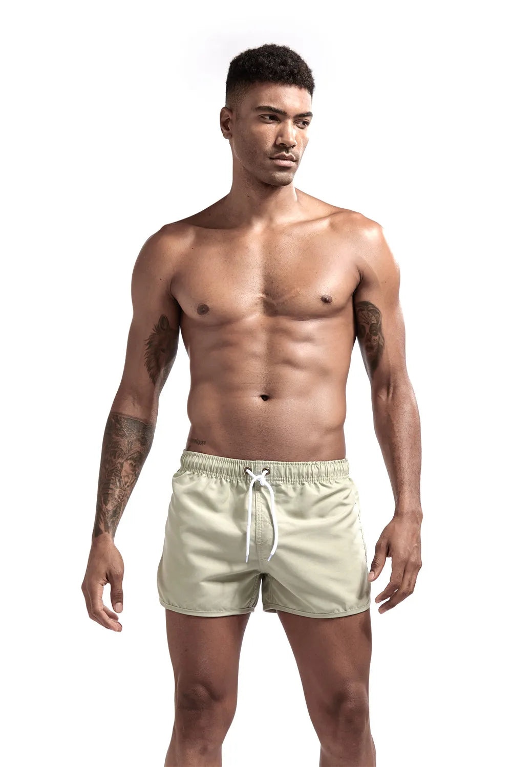 Man wearing light-colored swim shorts on a white background