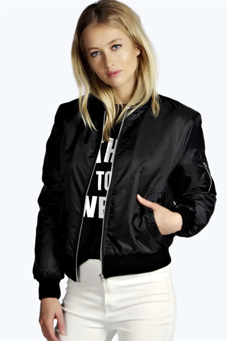 Woman wearing a black bomber jacket over a white hoodie with text, on a plain background