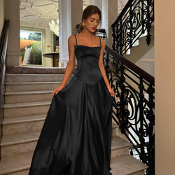 Woman in a black evening gown standing on a staircase