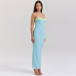 Woman wearing a light blue strapless gown with green trim on a white background
