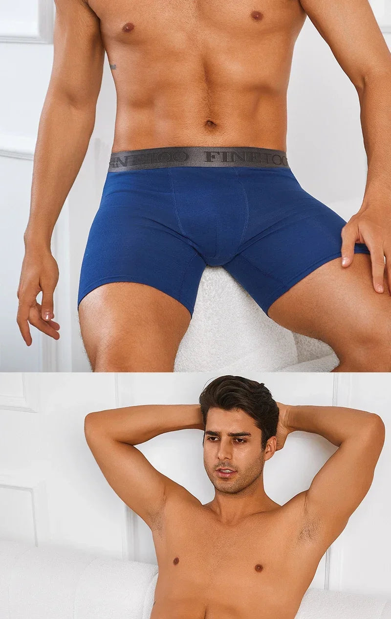 Man wearing blue underwear with a brand logo, standing against a white background.