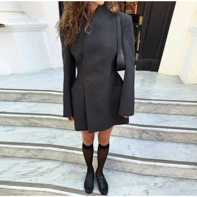 Person wearing a gray coat on marble steps