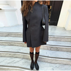 Person wearing a gray coat on marble steps