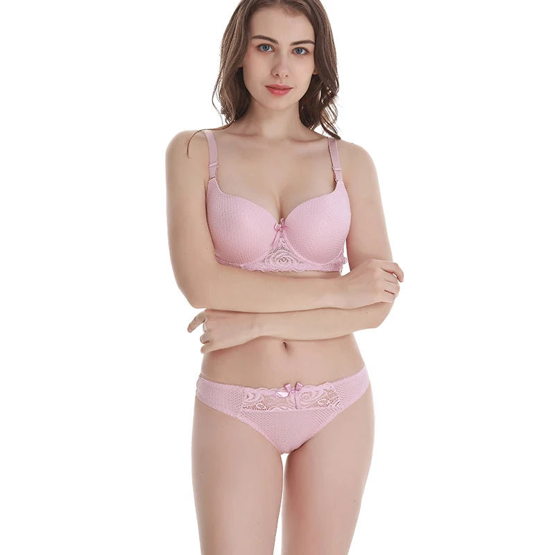 Woman wearing a pink bra and panties set on a white background