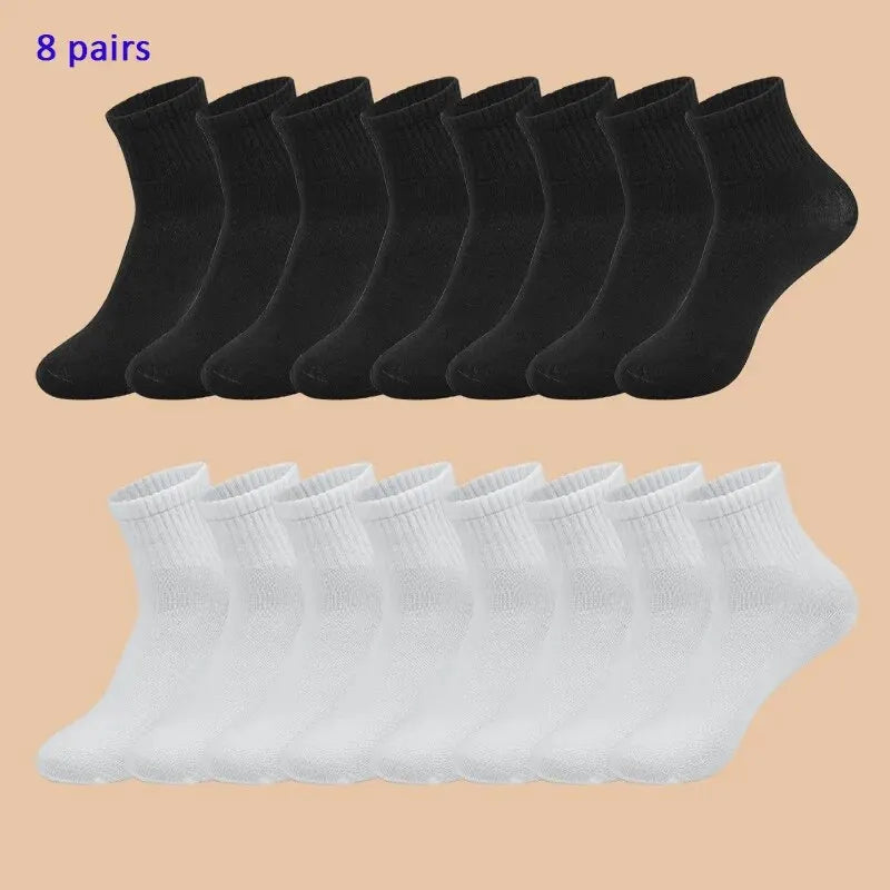 8 pairs of black socks on top and 8 pairs of white socks on bottom against a beige background
