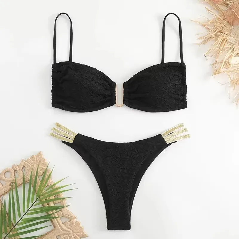 A two-piece black swimwear set with a wire-free U-shaped bandeau top and a mid-waist bikini bottom, featuring gold-colored accents on the straps.
