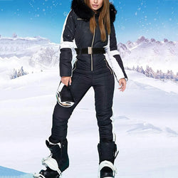 Person wearing a black ski suit with white accents in a snowy mountain landscape