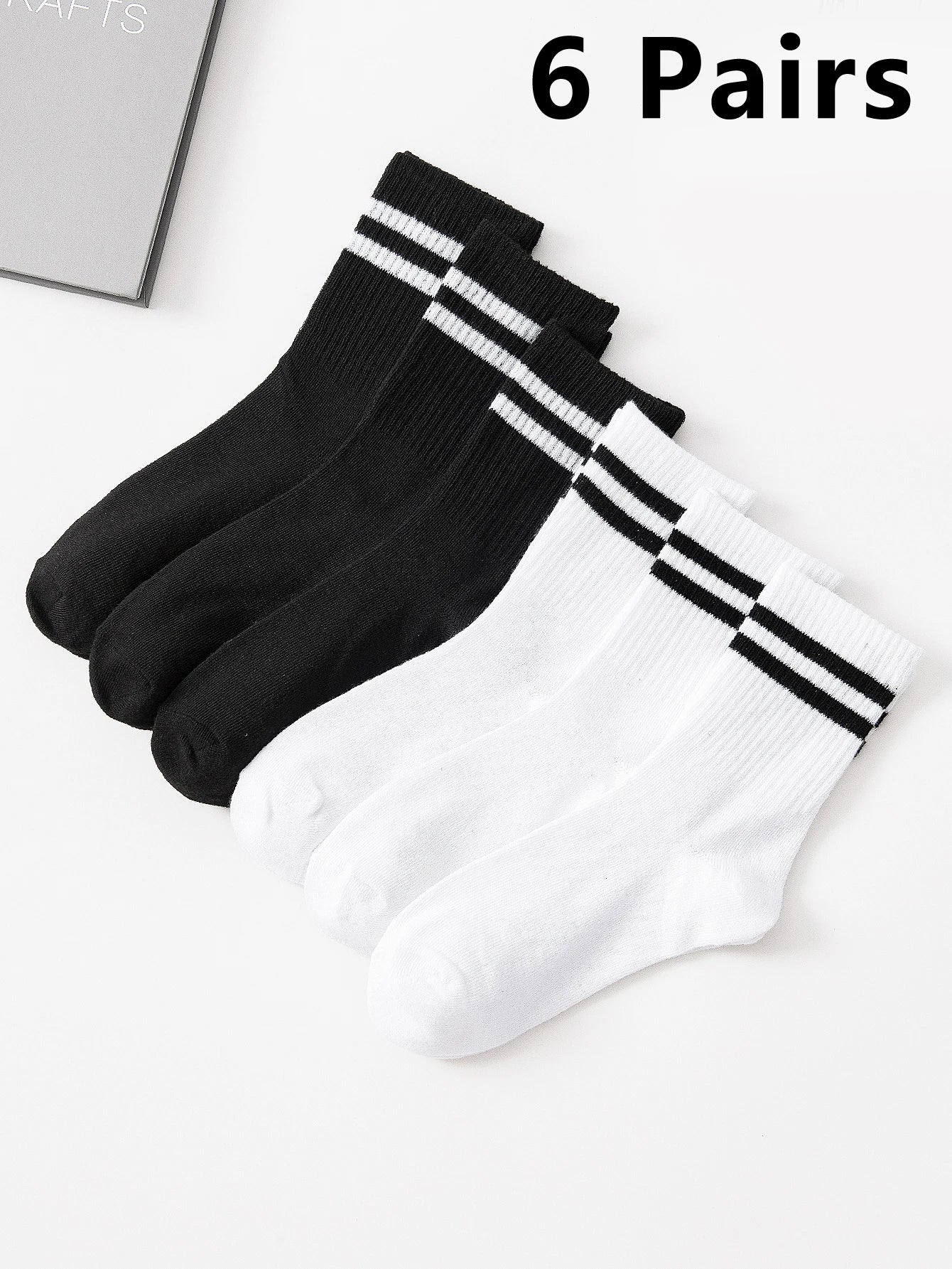 Six pairs of black and white socks with stripes on a light gray background.