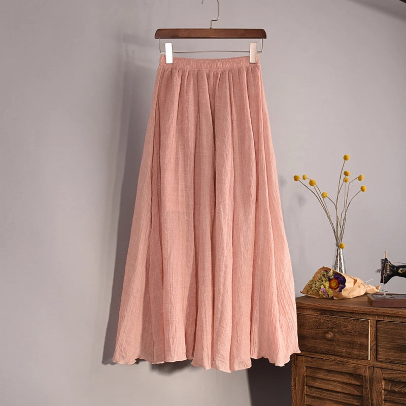 Pink skirt hanging on a hanger against a gray wall with a wooden dresser and decorative items in the background.