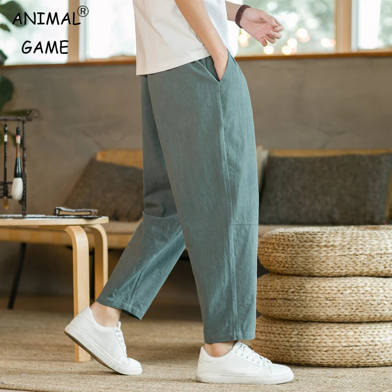 A pair of green, straight-legged men's trousers with a drawstring waist, ankle-length, made of cotton and linen fabric.
