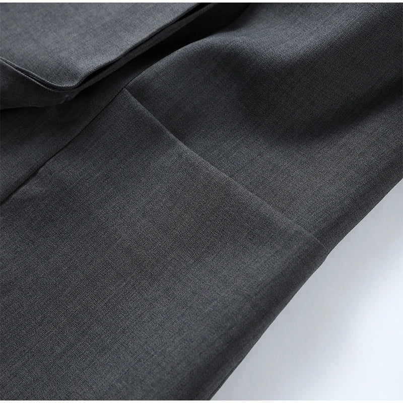 Close-up of dark gray fabric with a subtle pattern on a white background
