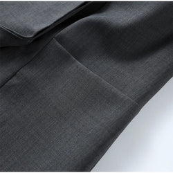 Close-up of dark gray fabric with a subtle pattern on a white background