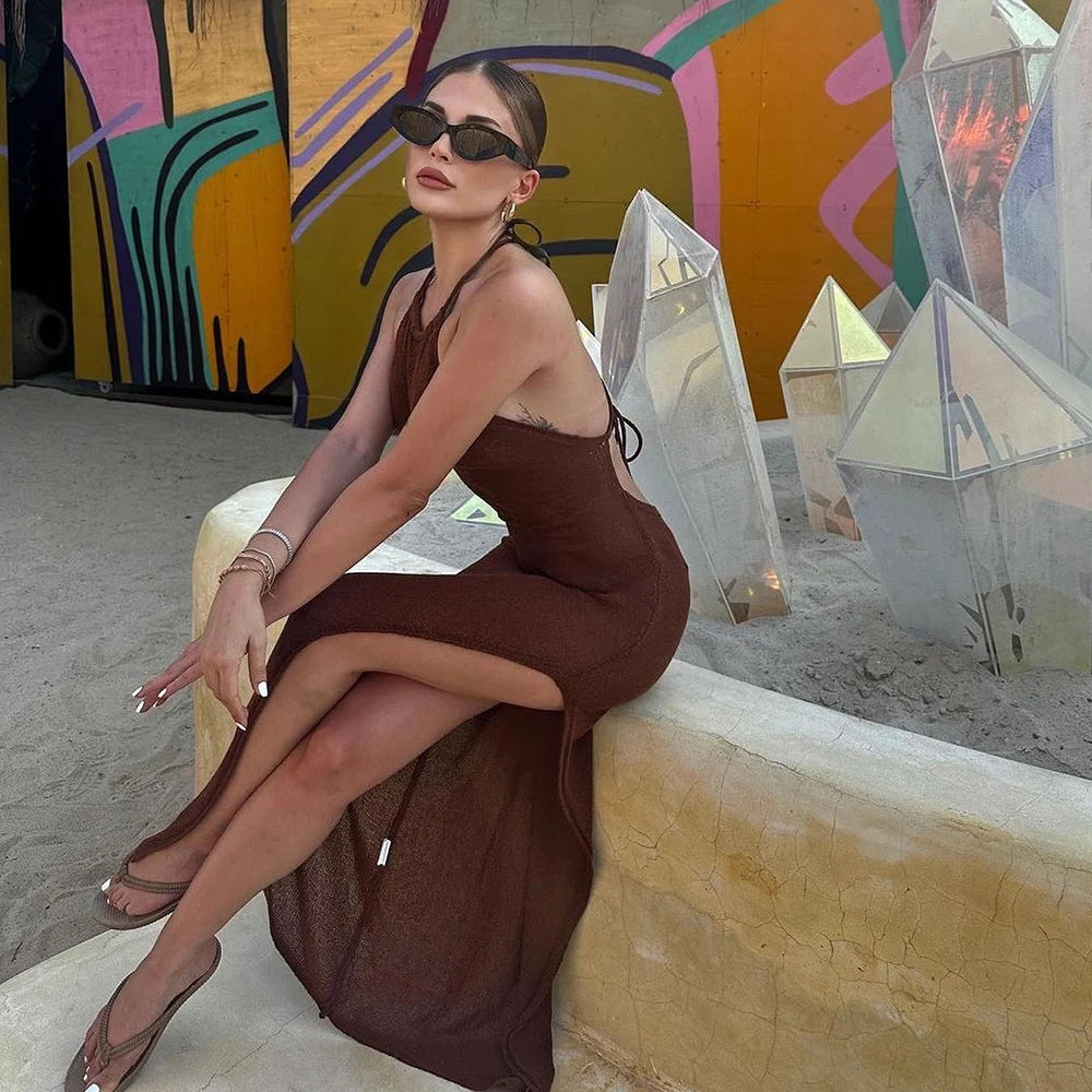 Woman in a brown dress sitting on a ledge with colorful abstract art in the background