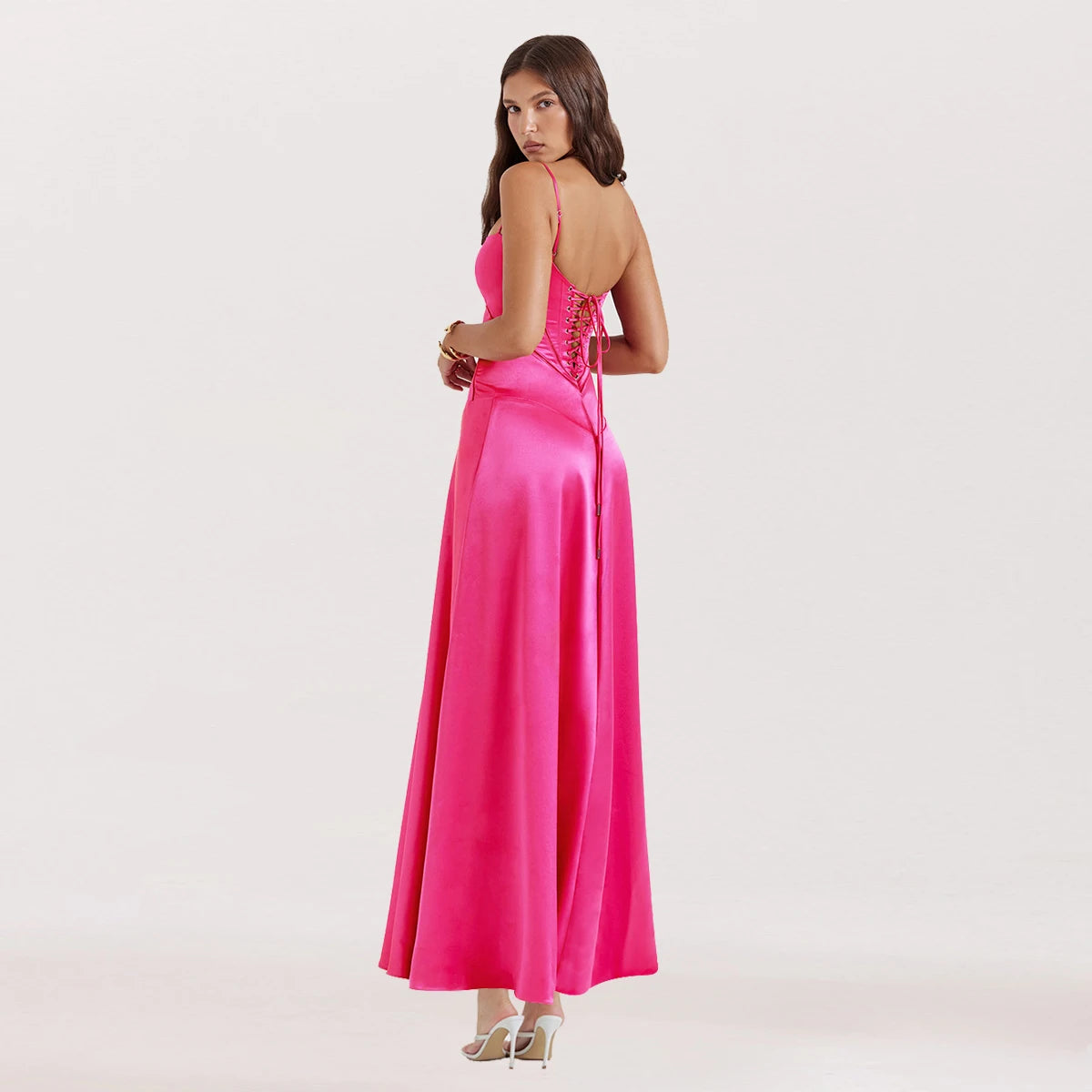 Woman wearing a bright pink evening gown with a white background