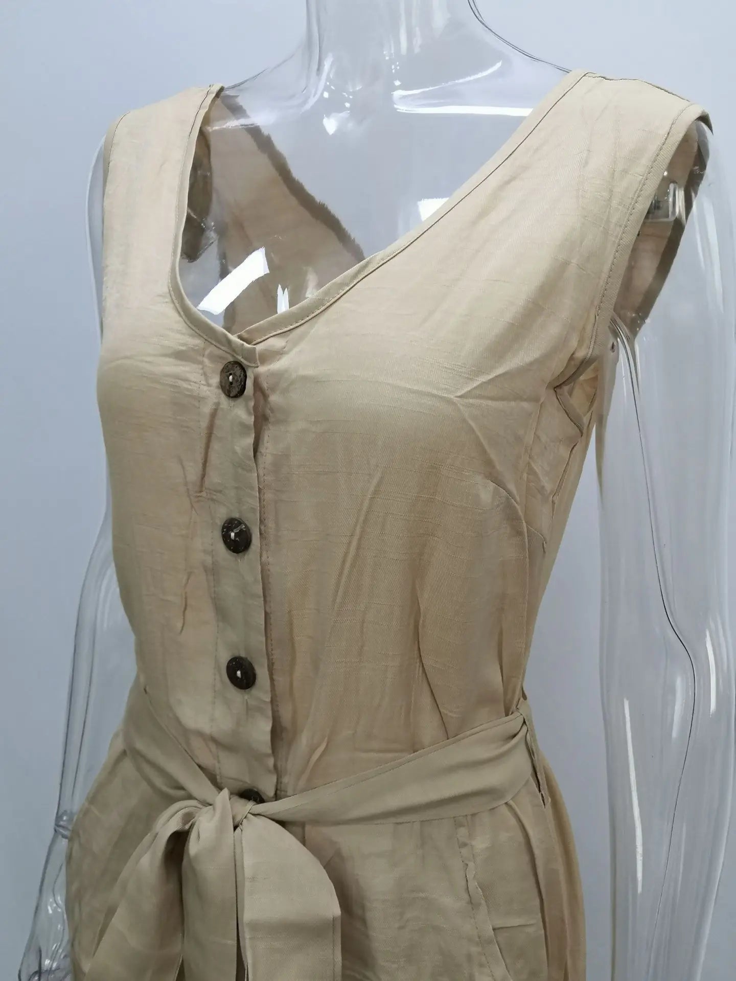 Beige sleeveless dress on a mannequin with a plain background
