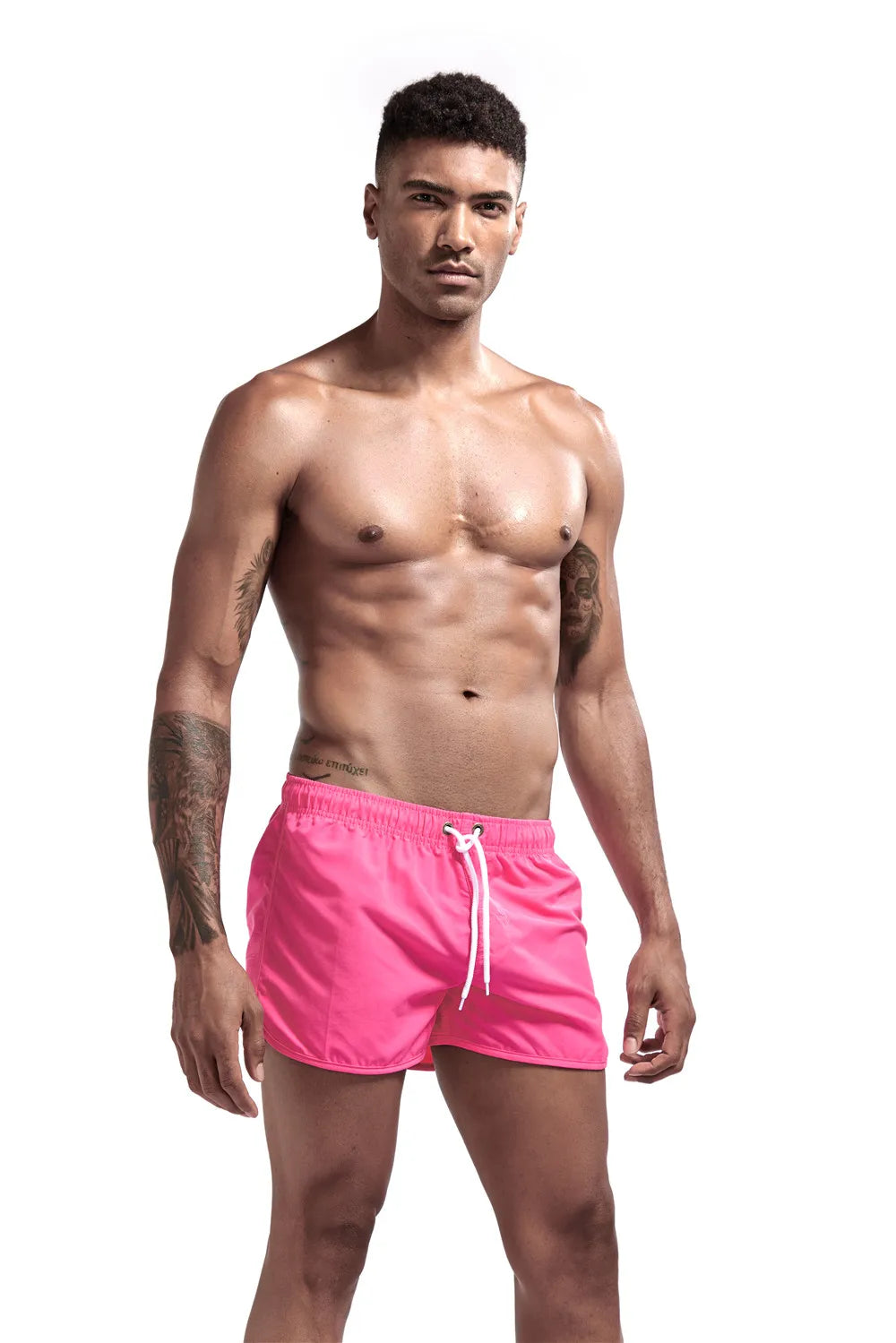 Man wearing pink swim shorts on a white background