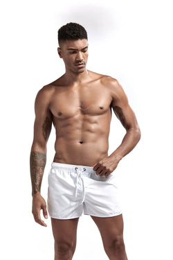 Man wearing white swim shorts on a white background