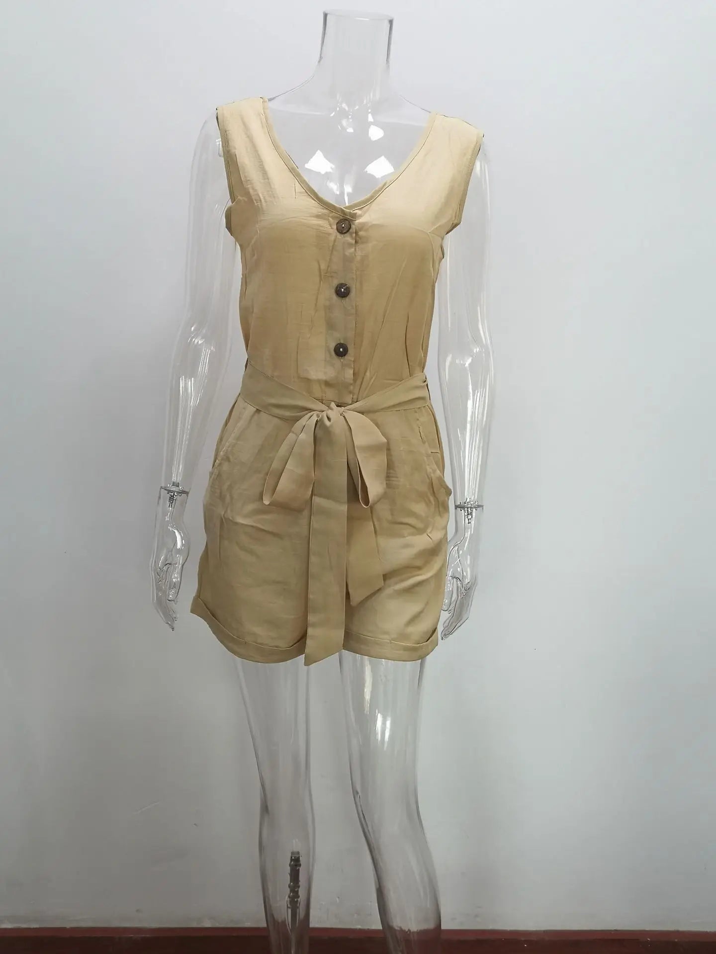 Beige romper on a transparent mannequin against a white background