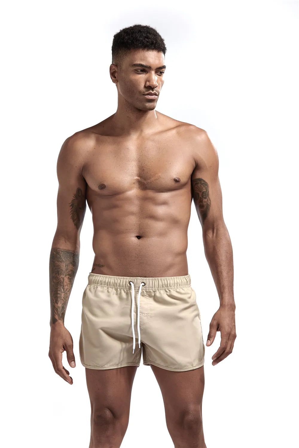 Man wearing beige swim shorts on a white background