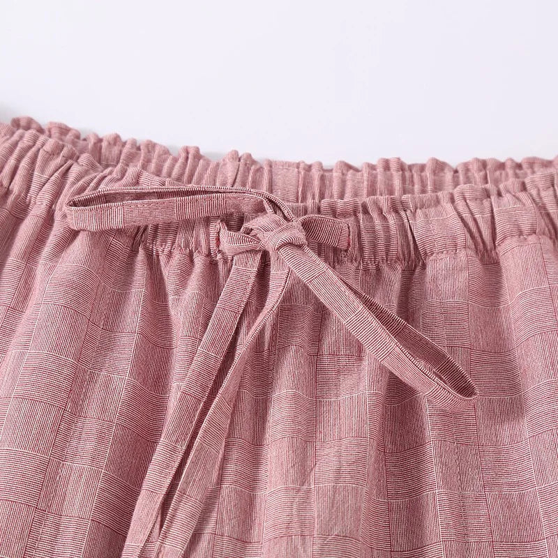 Close-up of pink textured fabric with a tie, on a light pink background
