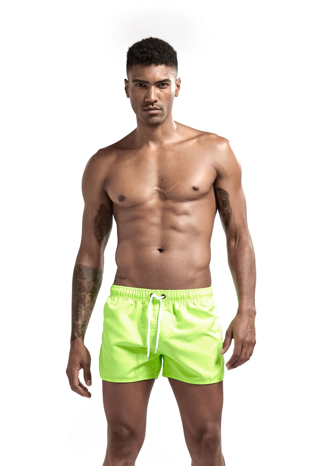 Man wearing bright green swim shorts on a white background