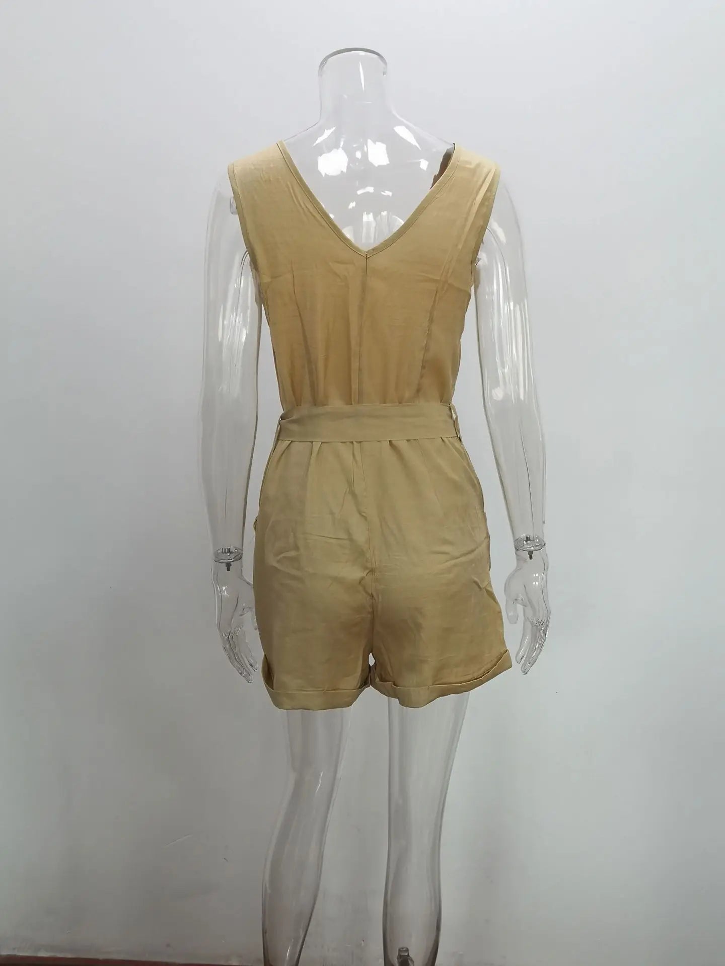 Mannequin wearing a beige romper against a white background