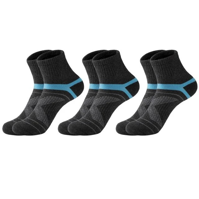 Three pairs of black socks with blue accents on a white background