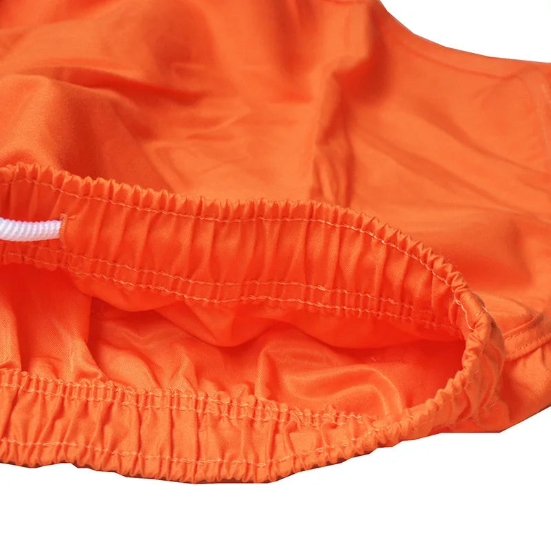 Close-up of orange shorts with a white waistband on a white background