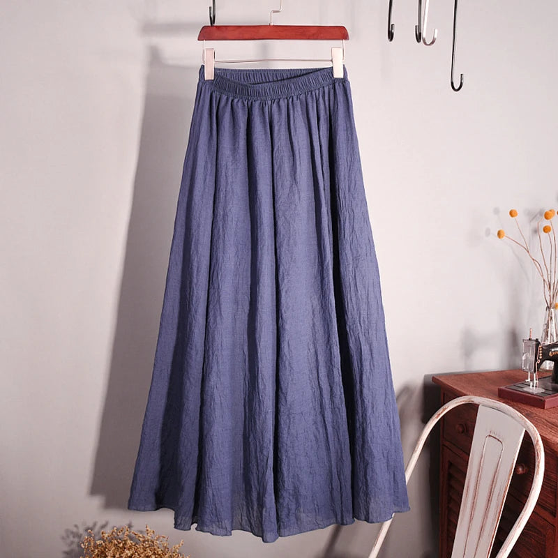 Blue skirt hanging on a hanger against a plain wall.