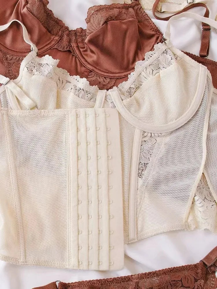 Collection of vintage-style lingerie including a beige corset and brown bodice on a white background.