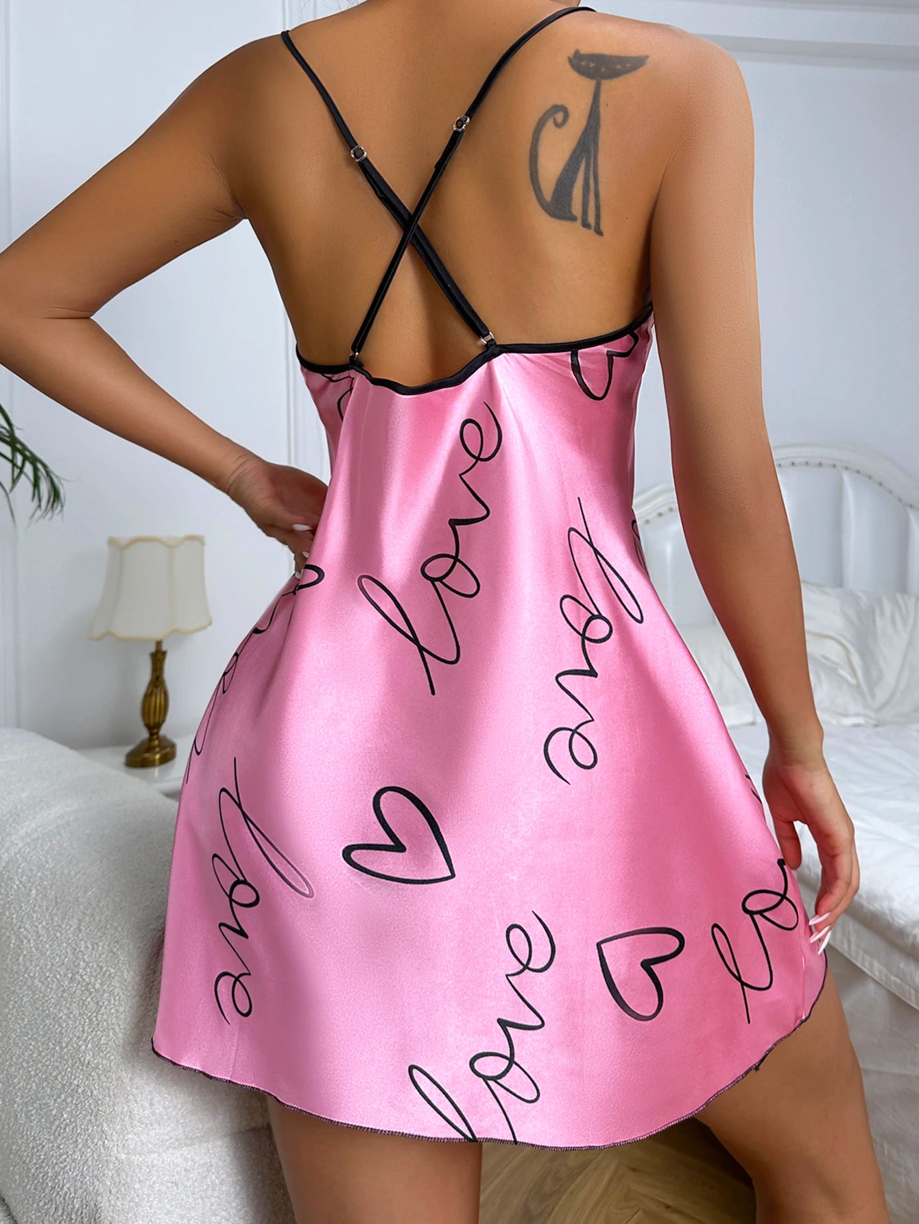 Pink satin nightgown with 'love' and heart designs on a white background