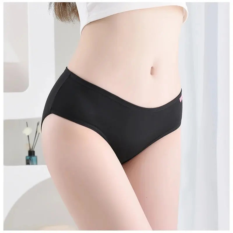 Person wearing black underwear against a neutral background
