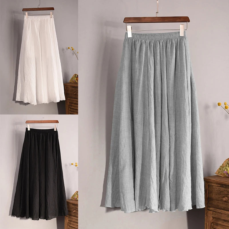 Three skirts in white, gray, and black hanging against a neutral background.