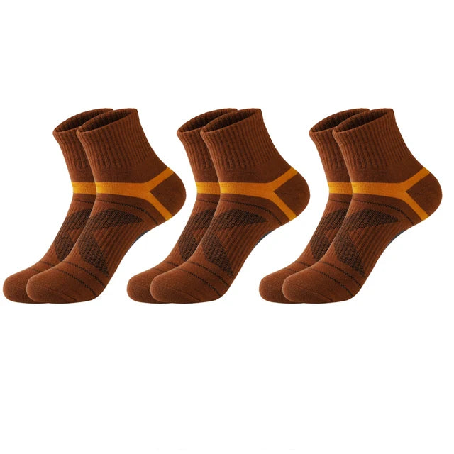 Three pairs of brown socks with orange accents on a white background