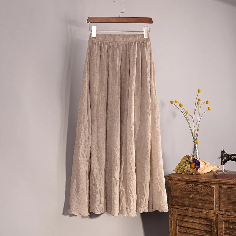 Beige skirt hanging on a wooden hanger against a plain wall with a wooden cabinet and decorative items in the background.