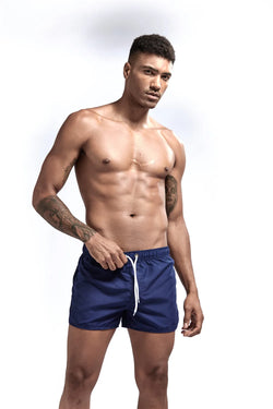 Man wearing blue swim shorts on a white background