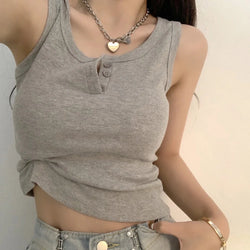 A woman wearing a gray ribbed button down sleeveless blouse with a round neckline and buttons at the bust area.