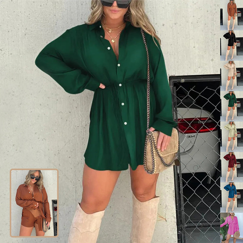A woman wearing a long sleeve button-up green dress with shorts, paired with knee-high boots and carrying a handbag.